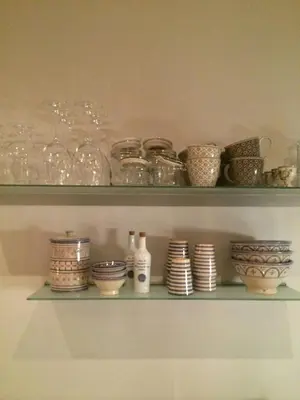 a shelf with glass jars and bowls on it at Cabin With Views Over Straumsundet in Øygarden