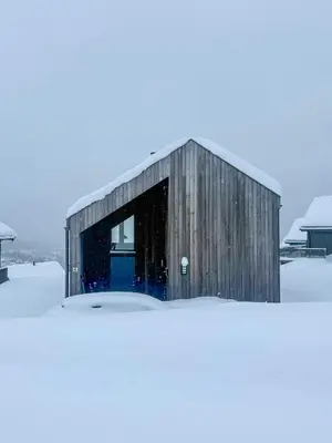 a barn with a blue door in the snow at Modern Cabin With Mountain Views In Rauland in Rauland