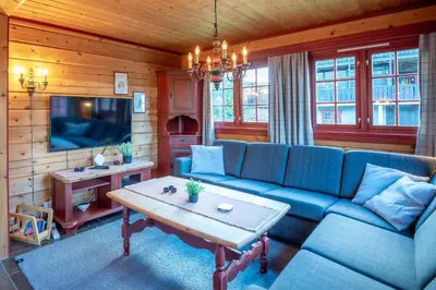 a living room with a blue couch and a table at Lisetra 716B in Trysil