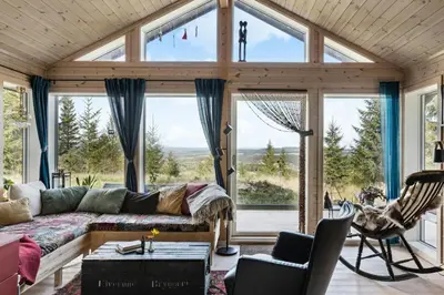 a living room with a couch and large windows at Family Cabin With Views Over Hadeland in Lunner