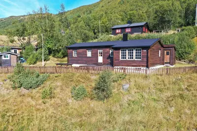 a wooden cabin in the middle of a field at Fjellro-Geilo Cabin Retreat in Geilo