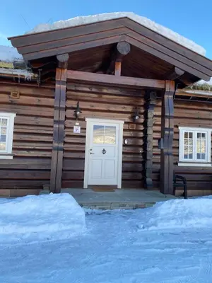 a log cabin with a white door in the snow at Log cabin at Hafjell in Øyer