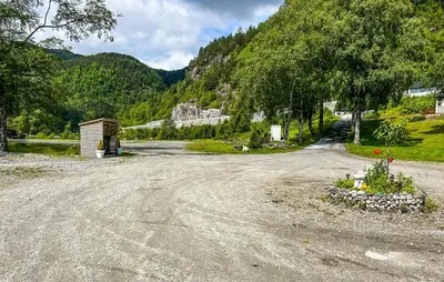 a dirt road with a building on the side of a mountain at Gorgeous Home In Lavik With House Sea View in Lavik