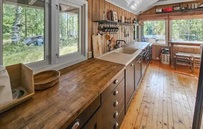 a kitchen with wooden floors and a counter with a sink at 2 Bedroom Nice Home In Noresund in Noresund