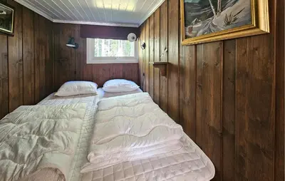 a bed in a room with wood paneling at 2 Bedroom Nice Home In Noresund in Noresund