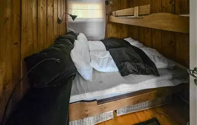 a large bed in a wooden room with at 2 Bedroom Nice Home In Noresund in Noresund