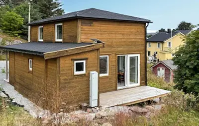 a small wooden house with a wooden deck at Lovely Home In Mausund With Wifi in Bogøyvær