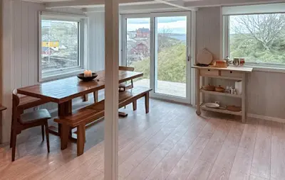 a dining room with a table and some windows at Lovely Home In Mausund With Wifi in Bogøyvær