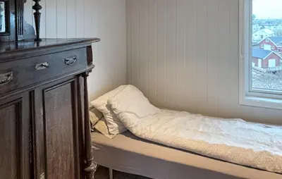 a bed in a room with a dresser and a window at Lovely Home In Mausund With Wifi in Bogøyvær