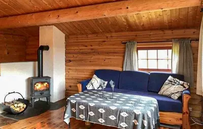 a living room with a blue couch and a stove at Stunning Home In Oppdal With Sauna in Oppdal