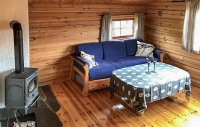 a living room with a blue couch and a stove at Stunning Home In Oppdal With Sauna in Oppdal