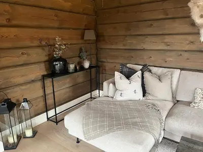 a living room with a couch and a chair at ØRNENIPA LODGE- flott hytte med 6 sov, 2 bad og beste beliggenhet in Gaustablikk