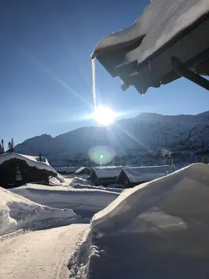 a snow covered slope with the sun in the background at ØRNENIPA LODGE- flott hytte med 6 sov, 2 bad og beste beliggenhet in Gaustablikk