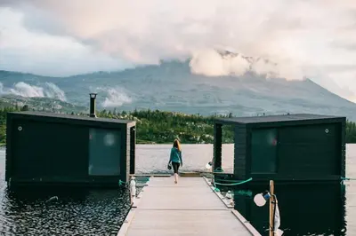 a woman walking on a dock in the water at ØRNENIPA LODGE- flott hytte med 6 sov, 2 bad og beste beliggenhet in Gaustablikk