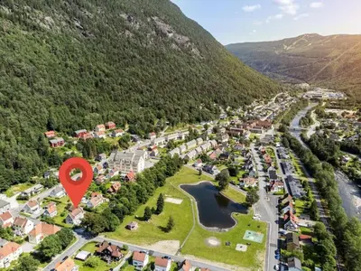 an aerial view of a town in the mountains with a red marker at Tveitopark Apartments B in Rjukan