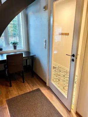 a door leading into a room with a desk and a table at Våkn opp til fantastisk utsikt in Bergen