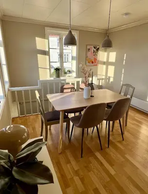 a dining room with a wooden table and chairs at Våkn opp til fantastisk utsikt in Bergen