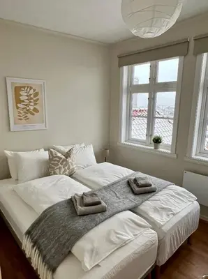 a bedroom with a large bed with two towels on it at Våkn opp til fantastisk utsikt in Bergen