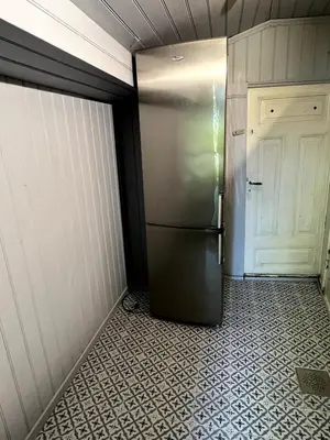 a refrigerator in a room with a door at Våkn opp til fantastisk utsikt in Bergen