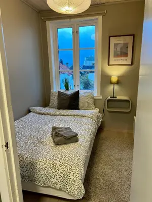 a small bedroom with a bed with a window at Våkn opp til fantastisk utsikt in Bergen