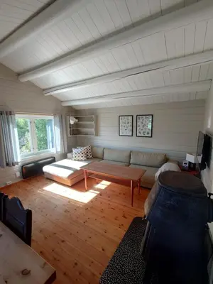 a living room with a couch and a table at Mountain view cabin in Torvik