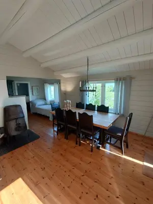 a dining room with a wooden table and chairs at Mountain view cabin in Torvik