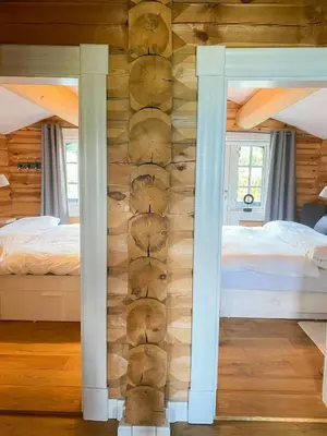 a bedroom with a log wall with two beds at Log Cabin With Panoramic Views At Voss Resort in Skulestadmo