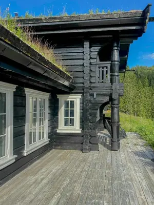 a log house with a porch and a deck at Log Cabin With Panoramic Views At Voss Resort in Skulestadmo