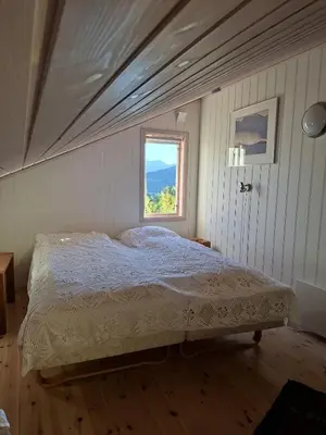 a bed in a bedroom with a window at Moderne hytte på Tingvoll nær sjø og turterreng in Tingvoll