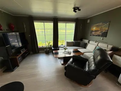a living room with a couch and a tv at Vistdal Panoramic View in Myklebostad