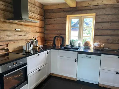 a kitchen with white cabinets and a stove top oven at Charming house by the fjord in Utvik