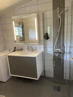 a bathroom with a sink and a shower and a mirror at Cabin with stunning views and outdoor jacuzzie in Leset