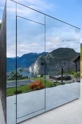 a glass house with a view of the mountains at Lingåsen Panorama! in Valldal