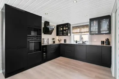 a kitchen with black cabinets and black appliances at Lingåsen Panorama! in Valldal