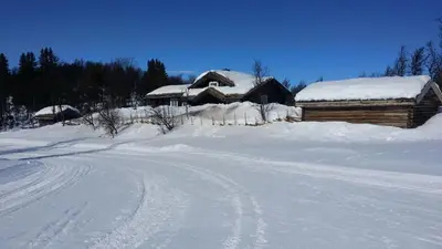a house is covered in snow next to a road at Nydelig hyttetun på Torpoåsen in Torpo