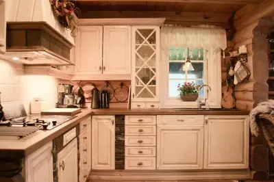 a kitchen with white cabinets and a window at Nydelig hyttetun på Torpoåsen in Torpo