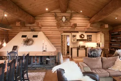 a living room of a log cabin with a fireplace at Nydelig hyttetun på Torpoåsen in Torpo