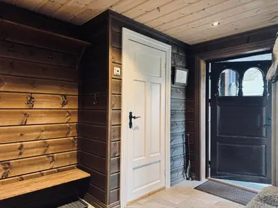 a white door in a room with wooden walls at Spacious cabin in the mountains in Gol