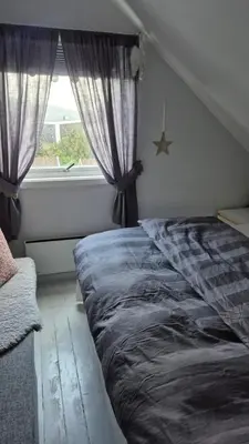 a bed sitting in a bedroom with a window at Charming family house with beautiful views! in Askøy