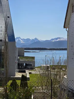 a building with a view of a lake and mountains at Modern City Apartment with garden and view in Molde