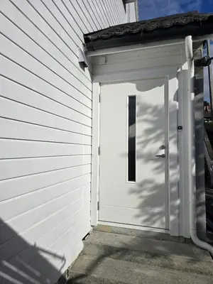 a garage with a white door on a house at Modern City Apartment with garden and view in Molde