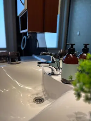 a bathroom sink with a soap dispenser on it at 3 soveroms leilighet-komfort og stil -perfekt for ferie og jobb in Gjøvik