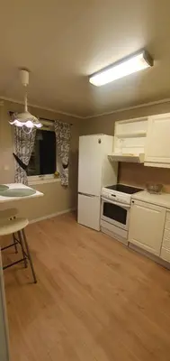 a kitchen with a white refrigerator and a table at Fotlandsvåg Guest Apartment in Bernes