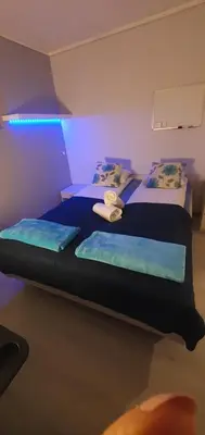 two beds in a room with purple lights at Fotlandsvåg Guest Apartment in Bernes