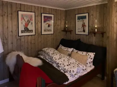a bedroom with a bed and pictures on the wall at Timber Cabin With Wood-Fired Hot Tub In Trysil in Trysil