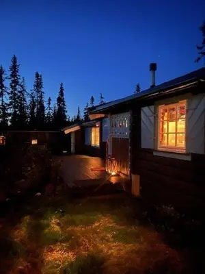 a house with its lights on in the yard at Timber Cabin With Wood-Fired Hot Tub In Trysil in Trysil