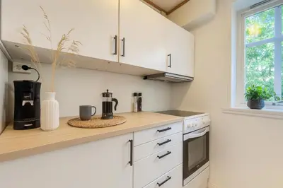 a kitchen with white cabinets and a counter top at Central & Quiet by Bryggen - Norwegians Minimum Age 25 in Bergen