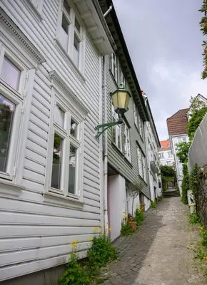 a white building with a street light next to it at Delightful Bryggen Apartment - Norwegians Minimum Age 25 in Bergen
