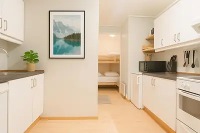 a kitchen with white cabinets and a picture on the wall at Delightful Bryggen Apartment - Norwegians Minimum Age 25 in Bergen