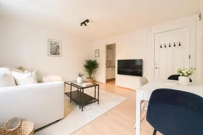 a living room with a white couch and a tv at Delightful Bryggen Apartment - Norwegians Minimum Age 25 in Bergen